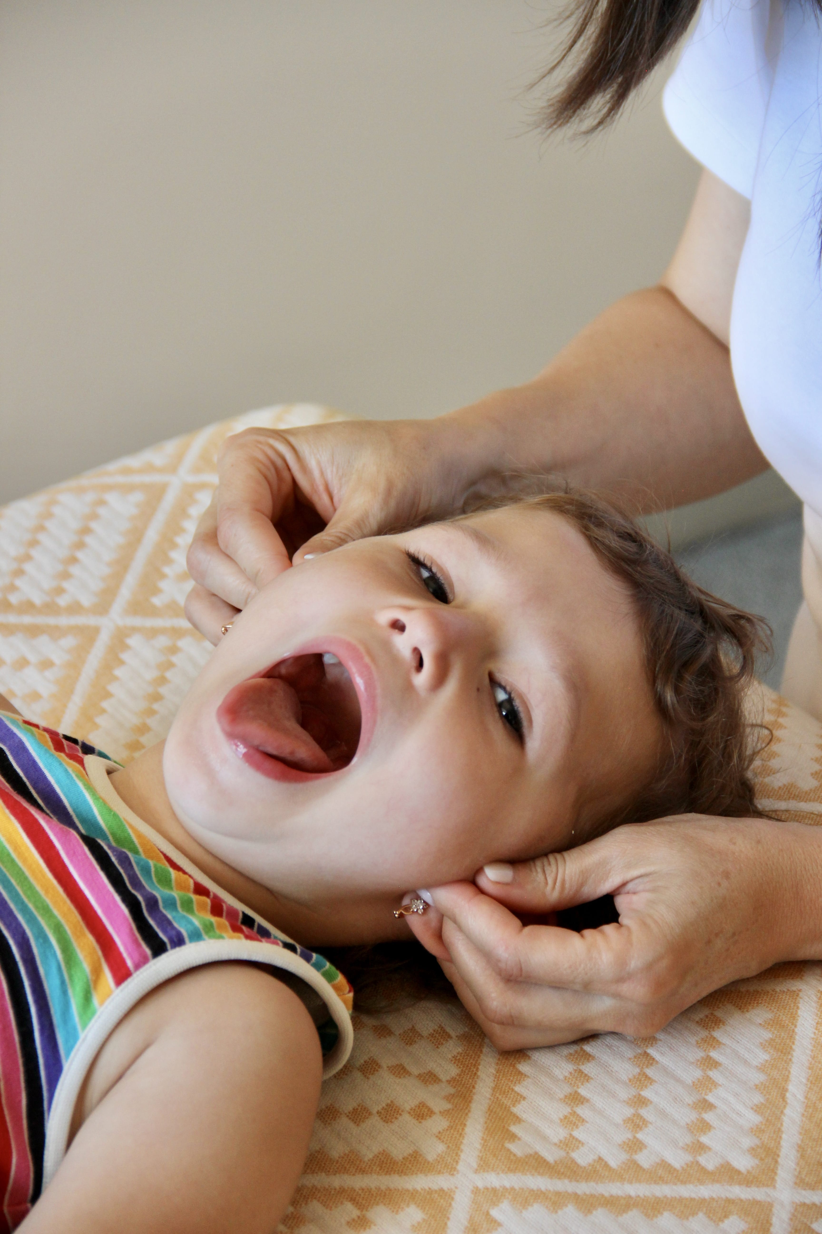 Joyful child during gentle osteopathic treatment